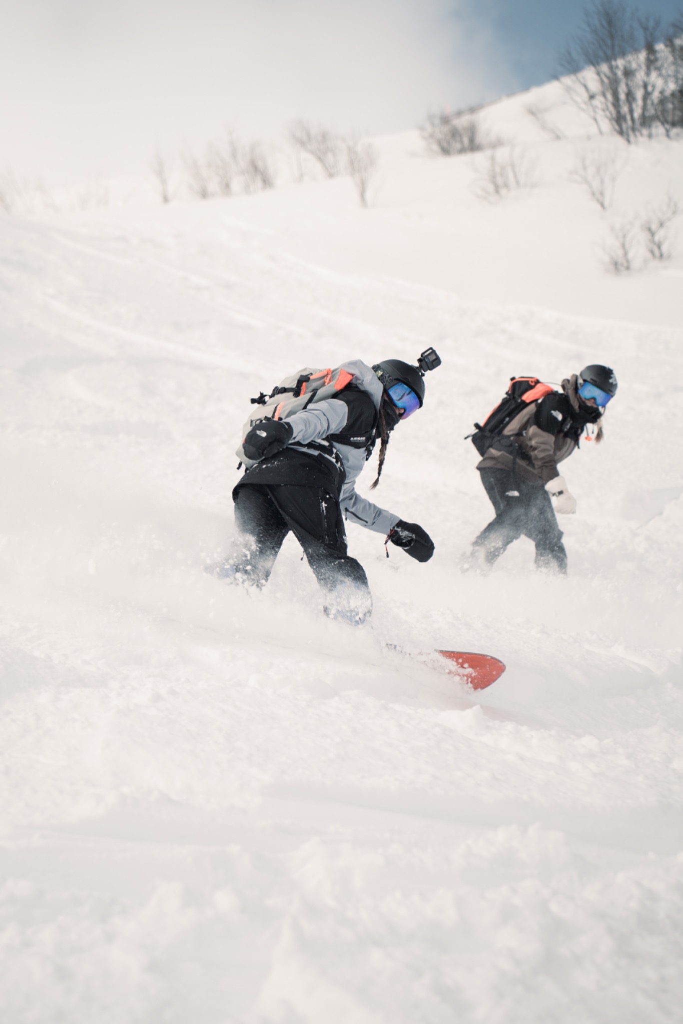 Deux snowboardeuses ensemble dans une pente enneigée